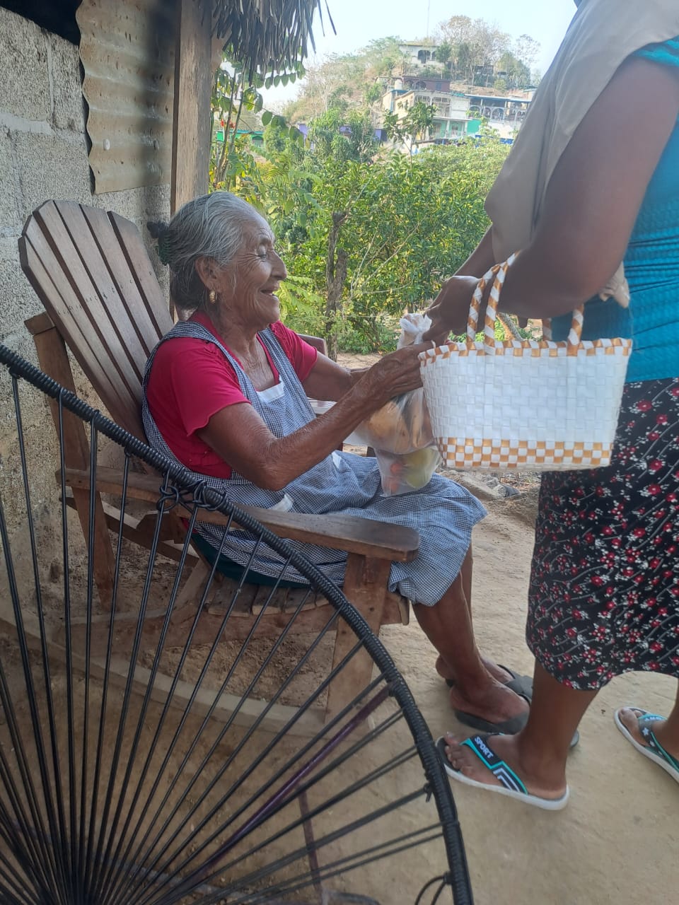 Entrega de un paquete alimentario a una beneficiaria de BAMX Región Olmeca
